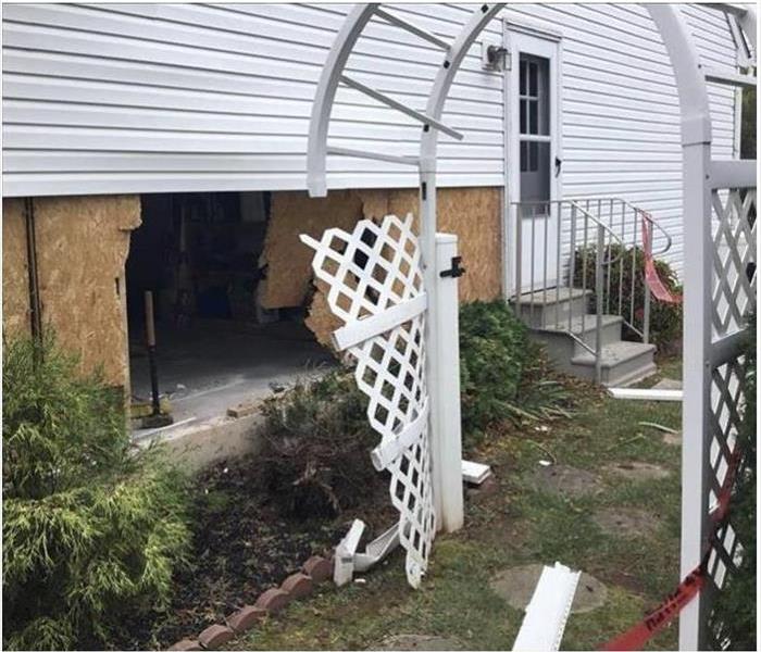 Hole on the side of the house where a car had previously hit.