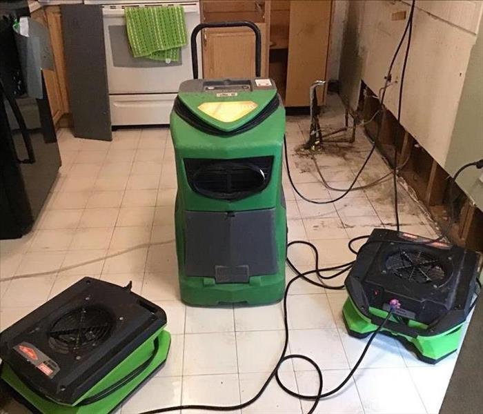 Dehumidifier and air movers set up in kitchen. 