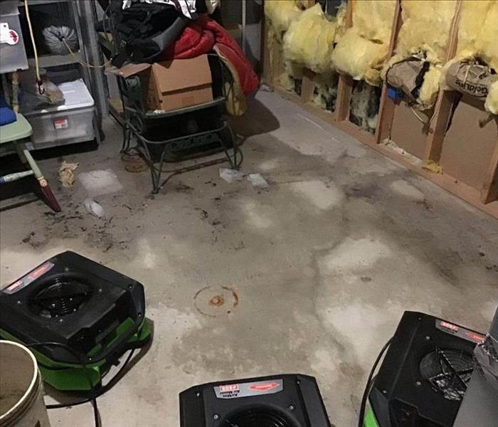Air movers on floor by wet cement flooring.