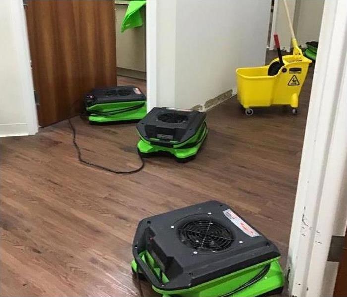 three air movers placed on wooden floor of a commercial blog.