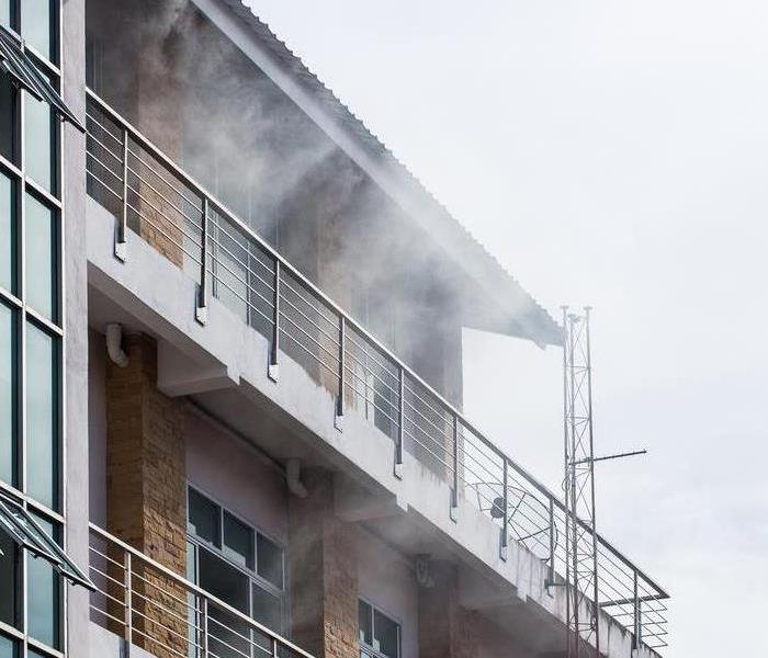 Smoke coming from a balcony of an apartment.