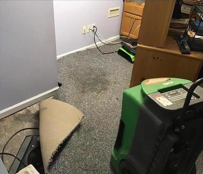Three air movers in an office drying carpet after storm damage